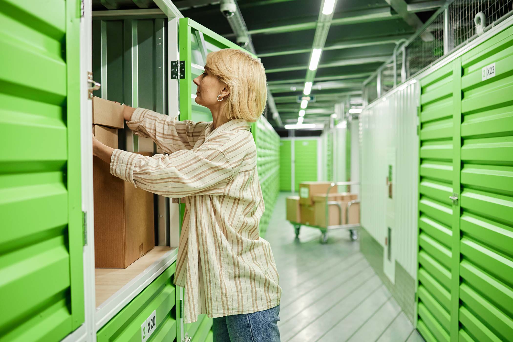 Middle-aged woman placing cardboard box from Amazon Wholesale Suppliers in USA